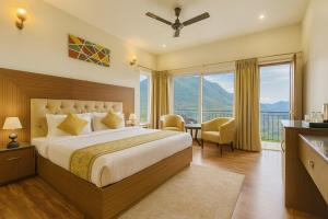 a bedroom with a bed and a large window at The Kempty Osasis - A Boutique Resort With Scenic Mountain View in Mussoorie in Mussoorie