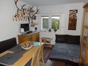 a living room with a table and a couch at Kleine Einliegerwohnung- komfort Home! in Lahnau