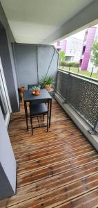 a balcony with a table and chairs on a floor at Cosy Appartement proche Bordeaux Proche centre ville in Villenave-dʼOrnon