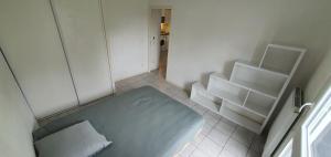 a small white room with a bed and shelves at Cosy Appartement proche Bordeaux Proche centre ville in Villenave-dʼOrnon