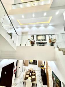 ein großes Wohnzimmer mit einem Tisch und einer Treppe in der Unterkunft PIO Suites Lekki in Lekki