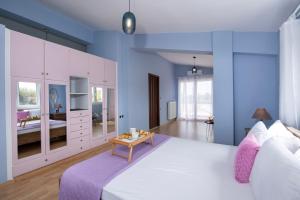 a bedroom with a large white bed and a table at Green Hill Villa in Daratso