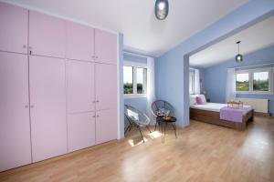 a bedroom with blue walls and a bed in a room at Green Hill Villa in Daratso