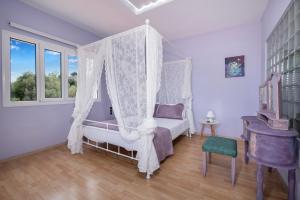 a bedroom with a canopy bed and a window at Green Hill Villa in Daratso +28 photos