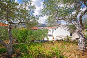 een wit huis met bomen op de voorgrond bij Holiday house with WiFi Trogir - 15319 in Trogir