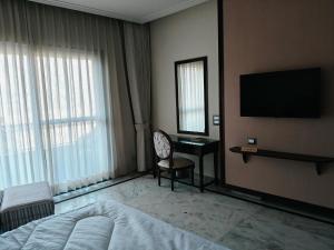 um quarto com uma cama, uma escrivaninha e uma televisão em The Himalayan Residency em Duttnager