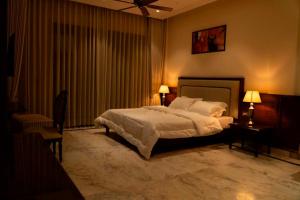 um quarto com uma cama grande e duas lâmpadas em The Himalayan Residency em Duttnager