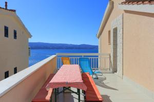 a balcony with a table and chairs and the water at Apartments with parking space Stanici, Omis - 2818 in Tice