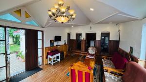a large living room with a chandelier and a table at Hidden heritage ins in Ooty