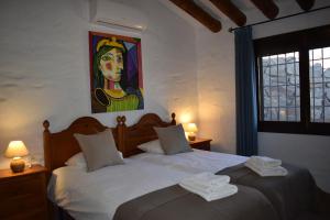 two beds in a bedroom with a painting on the wall at Finca Lagarillo with private Pool in Cómpeta +26 photos