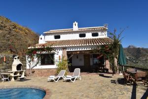 a house with two chairs and a swimming pool at Finca Lagarillo with private Pool in Cómpeta