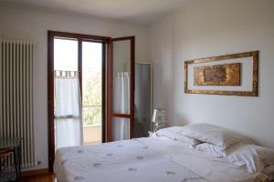 una camera da letto con un letto bianco e una finestra di Casa della Zia a Marotta