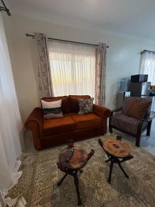 a living room with a couch and a table at Waridi is a modern, cosy penthouse in Mtwapa town in Mtwapa
