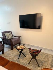 a living room with a flat screen tv on the wall at Waridi is a modern, cosy penthouse in Mtwapa town in Mtwapa +2 photos