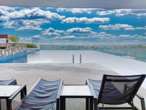 a view of a pool with two chairs and a table at AZ 3Rooms Apartment at De Centrum Bangi-Putrajaya in Kajang