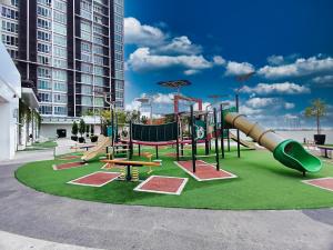 a playground with a slide on a green at AZ 3Rooms Apartment at De Centrum Bangi-Putrajaya in Kajang