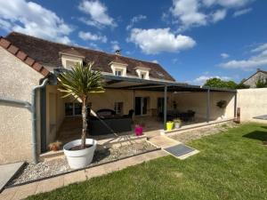 a house with a palm tree in a yard at Le Rétro Club Discothèque in Champlay