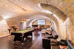 a living room with a pool table in a brick wall at Le Rétro Club Discothèque in Champlay