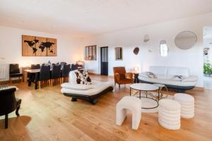 a living room with white furniture and a dining room at Le Rétro Club Discothèque in Champlay
