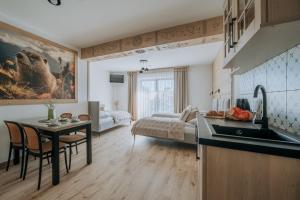 a kitchen with a sink and a table and a bedroom at Willa Janowa in Bukowina Tatrzańska