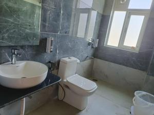 a bathroom with a white toilet and a sink at Hotel DS Villa in Zirakpur