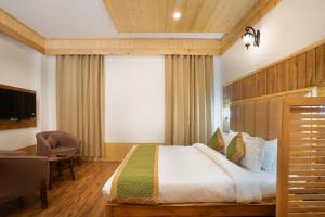 a bedroom with a bed and a chair and a window at Hotel DS Villa in Zirakpur
