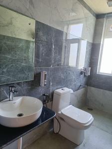 a bathroom with a white toilet and a sink at Hotel DS Villa in Zirakpur