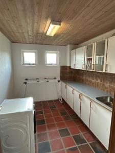 a kitchen with a sink and a washing machine at Hyggelig 2 plans villa i Hørning in Hørning