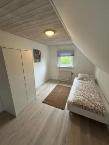 an attic bedroom with a bed and a window at Hyggelig 2 plans villa i Hørning in Hørning +26 photos