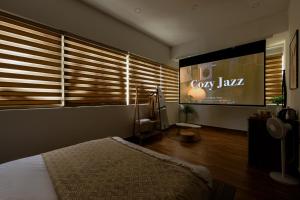 a bedroom with a large tv and a bed at The Morris Central Hotel - O'TEL in Da Lat