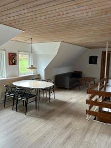 a living room with a table and chairs and a couch at Hyggelig 2 plans villa i Hørning in Hørning