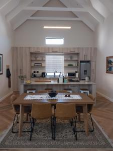 a large kitchen with a wooden table and chairs at White Feather Guest Room and Wellness Spa in Yzerfontein