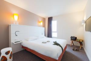 Cama ou camas em um quarto em Hôtel Confort La Rochelle Centre les Minimes