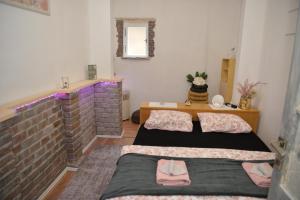 バチュカ・パランカにあるStan na dan 4youのレンガの壁、ベッド2台が備わるベッドルーム1室が備わります。