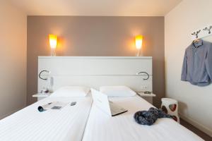 Cama ou camas em um quarto em Hôtel Confort La Rochelle Centre les Minimes