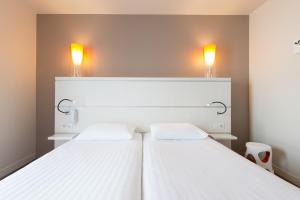Cama ou camas em um quarto em Hôtel Confort La Rochelle Centre les Minimes