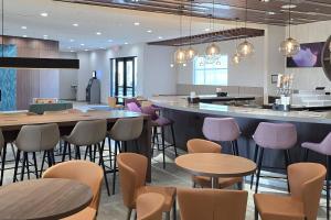 een restaurant met tafels en stoelen en een bar bij Cambria Hotel Northlake Conference Center - Roanoke in Northlake