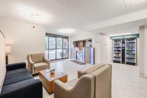 een woonkamer met een bank, stoelen en een tafel bij Clarion Pointe Winston - Salem Downtown in Winston-Salem