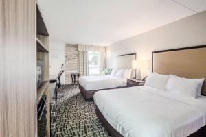 een hotelkamer met twee bedden en een televisie bij Clarion Pointe Winston - Salem Downtown in Winston-Salem