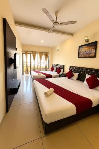 a hotel room with three beds and a tv at Hotel JB Regency & Banquet Hall ll Family Hotel ll Top Rated Property in Chandīgarh