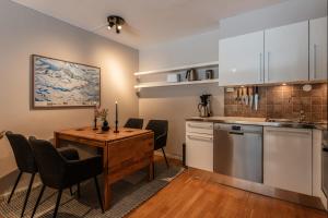 a kitchen and dining room with a table and chairs at Geilo Town Centre - Apartment with a Superb Location and walking Distance to Everything in Geilo +4 photos