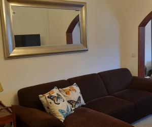 a brown couch in a living room with a mirror at Amarante Residence in Amarante