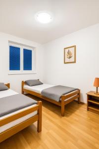 Dos camas en una habitación con suelo de madera y ventanas. en Panorama, en Negotin