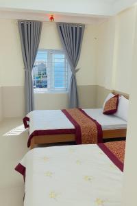 a bedroom with two beds and a window at Phương Phương 2 Hotel in Ha Tinh