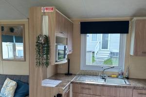 ニューキーにあるNewquay - Caravan - Sleeps 8 - Parking - Seasideのシンクと窓のあるキッチン