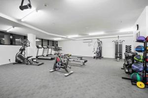 une salle de sport avec plusieurs tapis de course et vélos d'exercice dans l'établissement Decent views 3BR in Doncaster Central, à Doncaster