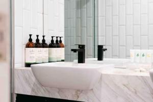 une salle de bains avec un lavabo et des bouteilles d'alcool dans l'établissement Decent views 3BR in Doncaster Central, à Doncaster 6 autres photos