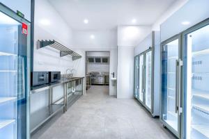 a kitchen with white walls and glass doors at Capsule Hostel Perth - note - Valid passport required to check-in in Perth