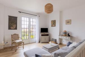 a living room with a couch and a tv at maison Amboise in Limeray