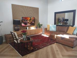 a living room with a couch and a table at White Feather Guest Room and Wellness Spa in Yzerfontein